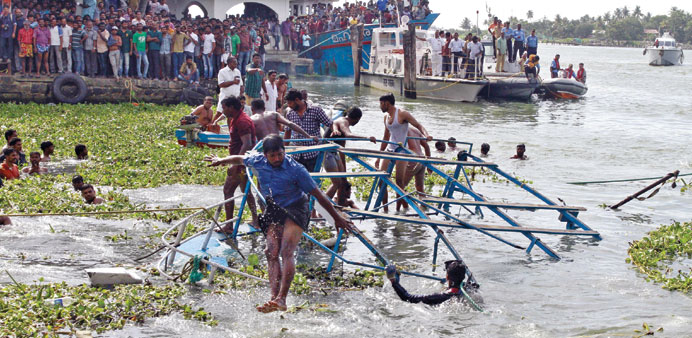 A rescuer jumps from the damaged ferry as it is pulled to the banks of Vembanad Lake at Fort Kochi in Kerala.