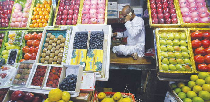 A fruit vendor speaks on his phone while sitting at his fruit stall at a wholesale market in yesterday. Indiau2019s headline inflation picked up in Februa