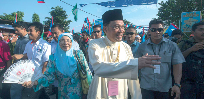 Opposition leader Anwar Ibrahim (centre) arrives accompanied by his wife Wan Azizah to submit his election nomination in Berapit.
