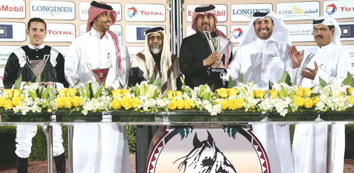 QREC official Ali al-Saaq (third from left) is seen with the winners of the Al Busayyir Cup at the Qatar Racing and Equestrian Club yesterday.