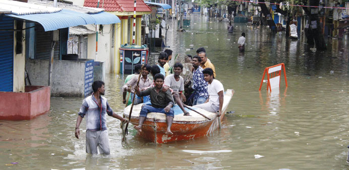 Volunteers with a boat move people to safety on a flooded street of Chennai yesterday.