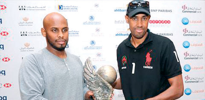    Al Rayyan captain Yaseen Moosa (right) and Al Sadd skipper Saad Abdulrahman pose with the Emir Cup yesterday.