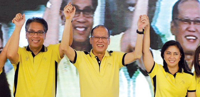 President Benigno Aquino holds up the hands of Manuel Roxas (left) and Leni Robredo (right), who he has endorsed as presidential and vice-presidential