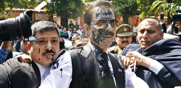 The Sahara group chairman Subrata Roy with his face smeared in ink thrown by a protester identified as Manoj Sharma arrives at the Supreme Court in Ne