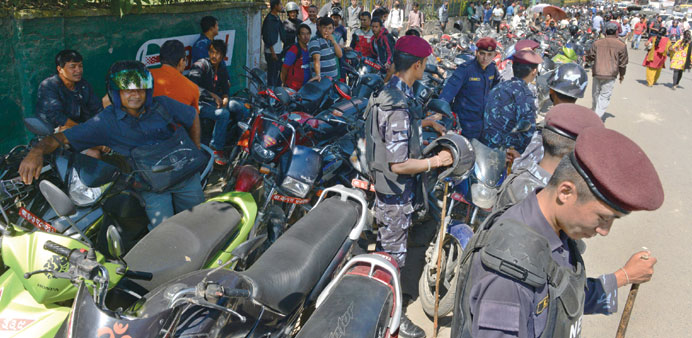 Nepalese police watch over a queue outside a gas station in Kathmandu.