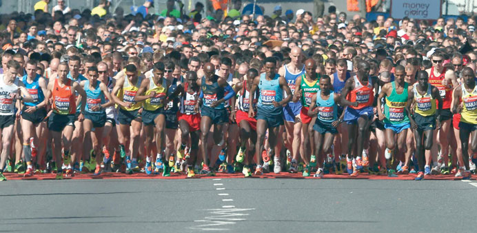 Competitors cross the start line at the beginning of the London Marathon in Greenwich, southeast London, yesterday.