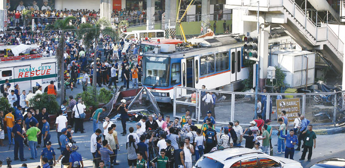 Filipino rescue and police units gather around a train after it overshot a terminal in Pasay City.