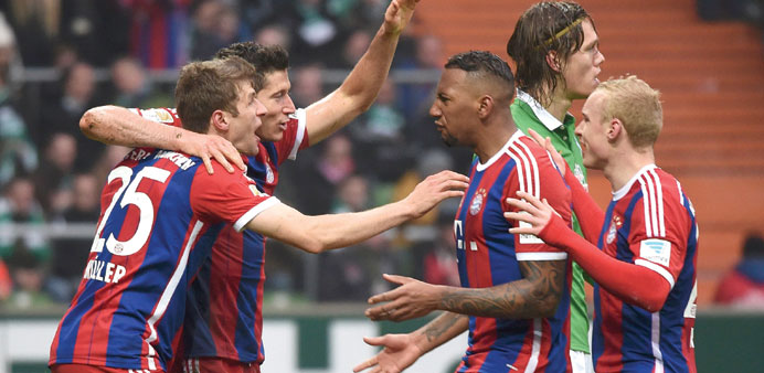 Bayern Munichu2019s Robert Lewandowski (2nd L) celebrates with teammates after he scored a goal with a header against Werder Bremen in Bremen yesterday. (