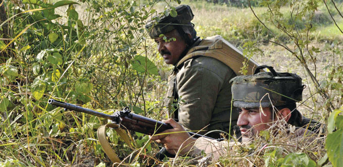 Soldiers take position during a gun battle with militants who launched an attack on an army camp in Samba district yesterday.