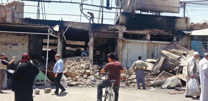 People inspect the damage at a market after an air strike by the Iraqi army in Mosul yesterday.