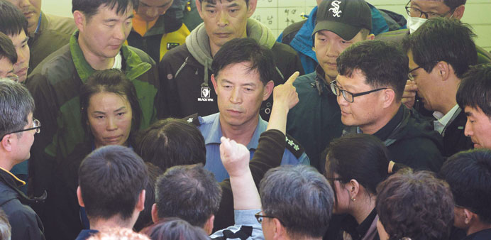 Relatives of victims of the Sewol ferry confront vice police chief Choi Sang-Hawan (centre) after they forcibly removed him from his office at Jindo h