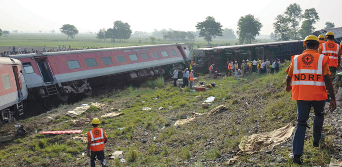 Rescuers are seen near overturned carriages of the Rajdhani Express train in Saran district of Bihar yesterday.