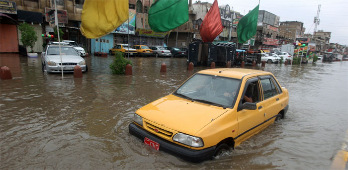 A Iraqi drives in a flooded street after heavy rainfall in the capital Baghdad