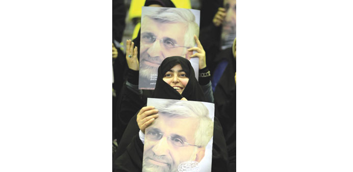 Supporters hold portraits of presidential candidate Saeed Jalili during a rally in Tehran yesterday.