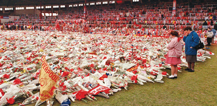 In a file picture taken on April 20, 1989, flowers, wreaths and tributes lie on the pitch at Anfield in memory of the 96 football fans who died in the