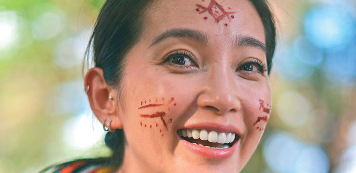 Chinese actress and UNEP goodwill ambassador Li Bingbing smiles after receiving temporary tribal markings from members of the Samburu tribe in Samburu