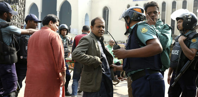 Security officials checking people as they enter at a mosque to attend the Friday prayer ahead of the 10th national election in Dhaka yesterday.