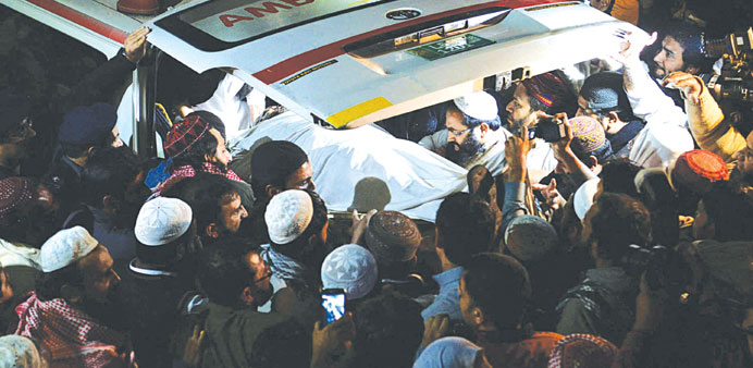 Supporters carrying the body of Maulana Shamsur Rehman outside a hospital following an attack by gunmen in Lahore yesterday.