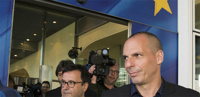 Greek Finance Minister Yanis Varoufakis (R) leaves the European Commission headquarters in Brussels 
