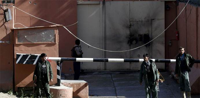 Afghan security force stand at the gate of a guesthouse after an attack in Kabul, Afghanistan