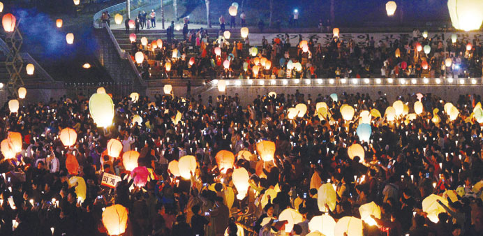 Mourners fly lanterns at a ceremony to celebrate the upcoming birthday of Buddha and to commemorate the victims of the capsized passenger ship Sewol i