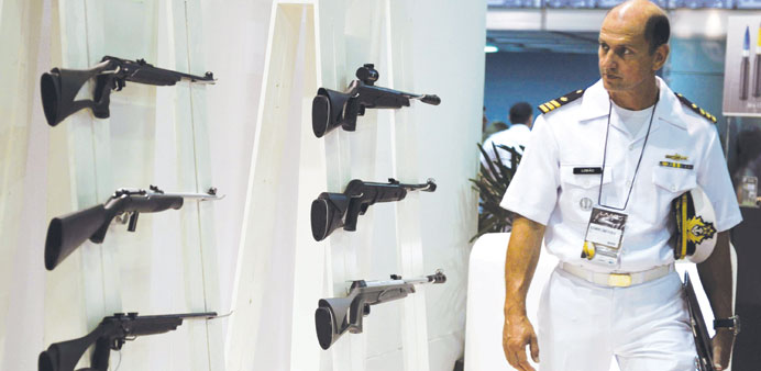 A navy officer looks at rifles on display during the first day of the LADD defence and security fair, the biggest in Latin America, in Rio de Janeiro,