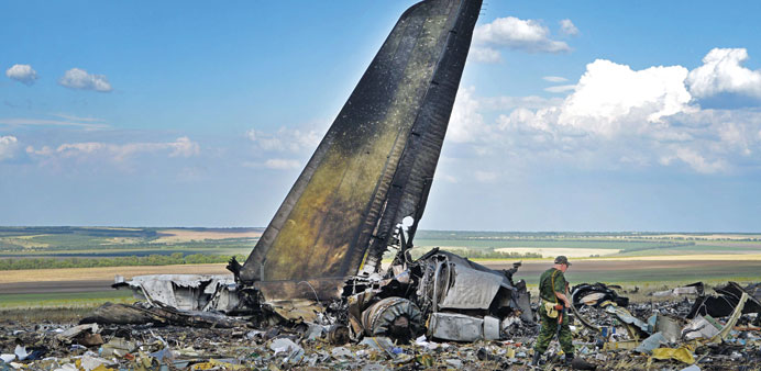 A pro-Russian militant looks through the debris of an IL-76 Ukrainian military transporter which was taken down early yesterday, on the outskirts of L
