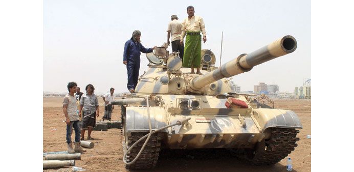 Supporters of the separatist Southern Movement stand on a tank in Aden yesterday.