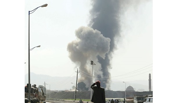 A man looks at smoke rising from the site of coalition air strikes in Sanaa yesterday.