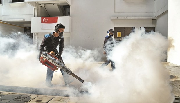 Pest control staff fumigate the drainage at Macpherson neighbourhood housing estate in Singapore yesterday.