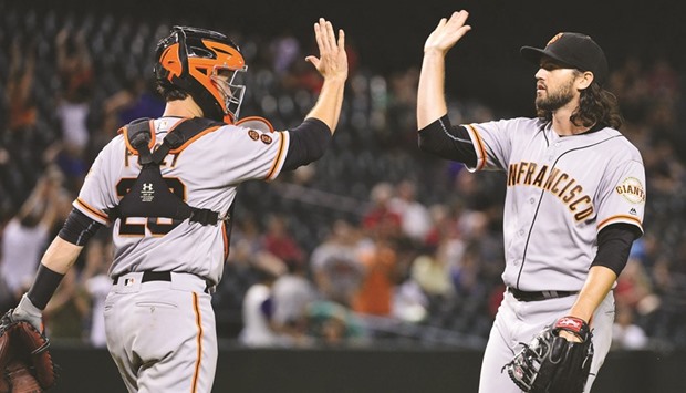 San Francisco Giants relief pitcher Cory Gearrin (62) is congratulated by catcher Buster Posey (28) after closing out the game against the Arizona Diamondbacks at Chase Field on Friday. The San Francisco Giants won 7-6 in extra innings. Picture: Jennifer Stewart-USA TODAY Sports