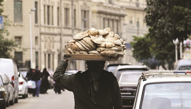 A man carries freshly baked bread on his head along a street in Cairo (file). Confusion over ergot threatens supplies in Egypt with a population of more than 90mn where the state buys wheat to subsidise bread and where shortages in the past have sparked food riots.