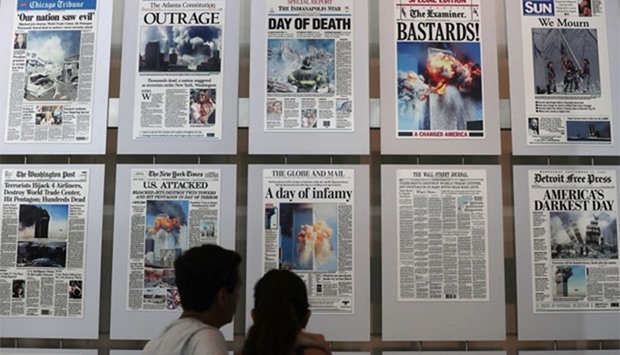 Visitors browse newspaper front pages with the story of the 9/11 terror attacks at the 9/11 Gallery of the Newseum