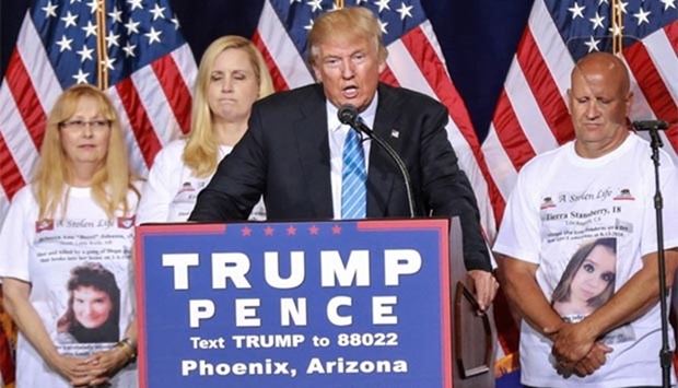 Republican presidential nominee Donald Trump stands on stage with parents who have lost family members, killed by undocumented immigrants, as Trump unveils his 10-point plan to crack down on illegal immigration during a campaigm event at the Phoenix Convention Center in Phoenix, Arizona on Wednesday.