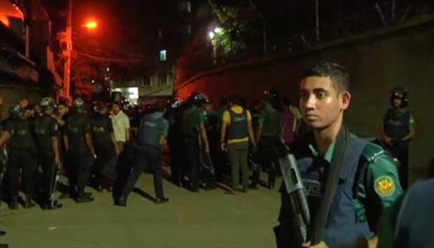 Members of the rapid action police battalion stand outside a house where suspected militants lived in Dhaka, in this still image taken from video.