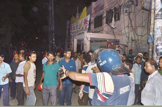 Policemen stand guard outside a house during a raid in Dhaka.