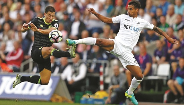 Chelseau2019s Eden Hazard (left) vies for the ball with Swansea Cityu2019s Kyle Naughton during the English Premier League match at The Liberty Stadium in Swansea, south Wales yesterday. (AFP)
