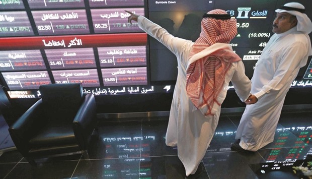 Investors talk as they monitor screens displaying stock information at the Saudi Stock Exchange (Tadawul) in Riyadh. Saudi Arabia is on course to join MSCI emerging-markets index in 2018, according to the chairman of the market regulator, after the kingdom gave foreign investors greater access to its almost $400bn stock exchange.