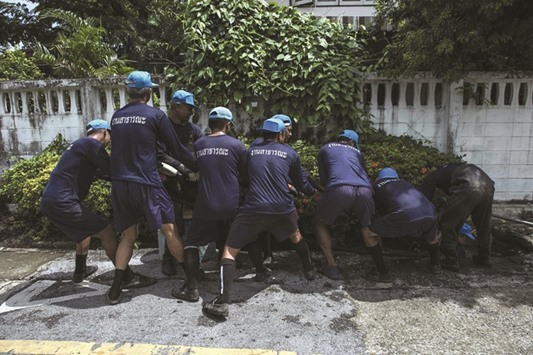 A recent photo shows volunteering prisoners pulling a metal bucket through a drain to dredge it from sewage and plastic waste in the outskirts of Bangkok.