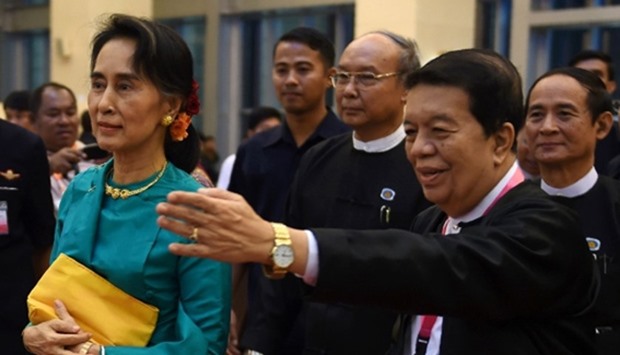Myanmar State Counsellor Aung San Suu Kyi (C) is escorted by government peace envoy Tin Myo Win (R)