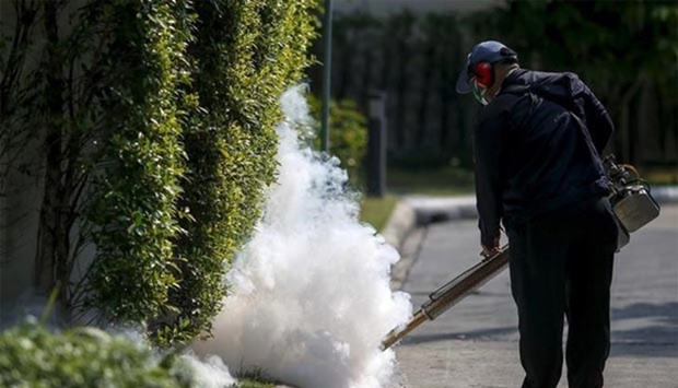 A worker sprays insecticide for mosquitoes in Bangkok early this year.