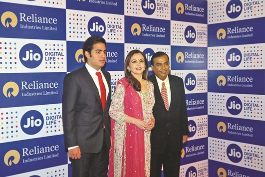 Mukesh Ambani (right), chairman of Reliance Industries, poses with his wife Nita (centre) and son Akash before addressing the companyu2019s annual general meeting in Mumbai yesterday. Reliance Jio Infocommu2019s service will debut on September 5 and will be free until December, after which the company will begin charging subscribers as little as Rs149 ($2.23) a month for data, Mukesh said yesterday.