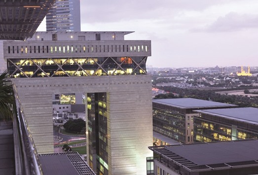 Office workers are seen illuminated at dusk as they sit inside the Dubai International Financial Centre (DIFC) in Dubai. More than 1,500 companies, including 425 financial firms, are now based in the tax-free business park with the number of employees increasing 14% to 21,000, the DIFC said in an e-mailed statement on Wednesday.