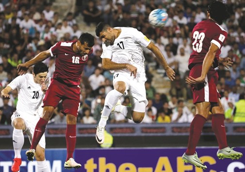 Iranu2019s Mehdi Taremi (C) and Qataru2019s Boualem Khoukhi fight for the ball during their World Cup 2018 Asian qualifying match at the Azadi stadium in Tehran yesterday.