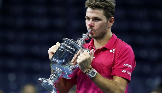 Stan Wawrinka celebrates with the trophy after defeating Novak Djokovic.