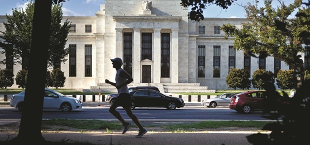 A runner passes the Federal Reserve building in Washington, DC. The Fedu2019s decision next week on whether to raise interest rates is a vital issue for markets and investors around the world.