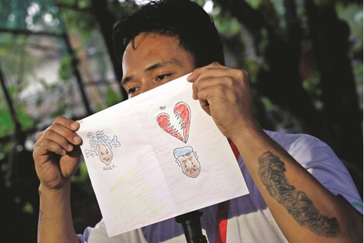A drug user undergoing rehabilitation shows an artwork he made during art therapy at a Centre for Christian Recovery drug rehabilitation centre in Antipolo city.