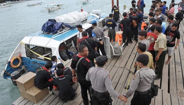 Police and investigators examine a ferry boat which was carrying tourists from Bali to Lombok following an explosion on board  on Thursday.