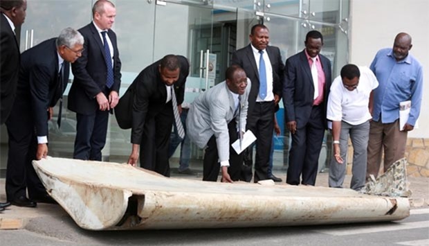 A Tanzanian official hands over a wing suspected to be a part of missing Malaysia Airlines jet MH370 discovered on the island of Pemba, off the coast of Tanzania, in Dar es Salaam on Thursday.
