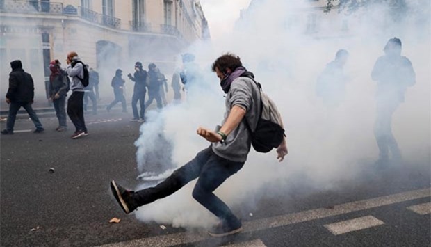 A demonstrator kicks tear gas during clashes with French riot police during a demonstration against controversial labour reforms of the French government in Paris on Thursday.